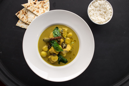 Chicken curry with rice on the side on black background. Studio shotの写真素材