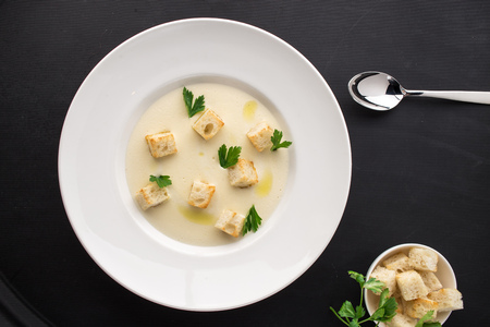 cream soup with parsley and bread on black bakground. Studio shotの写真素材
