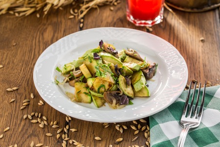 green zucchini grilled with champignon mushrooms on wooden table side viewの写真素材