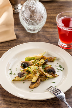 green zucchini grilled with champignon mushrooms on wooden table side viewの写真素材