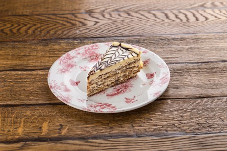 Traditional Hungarian Esterhazy cake with almond and chocolate isolated on wooden background side viewの写真素材
