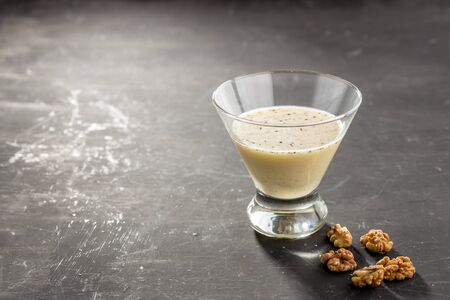 Chocolate Vanilla pudding with walnuts in a glass on black background side viewの写真素材
