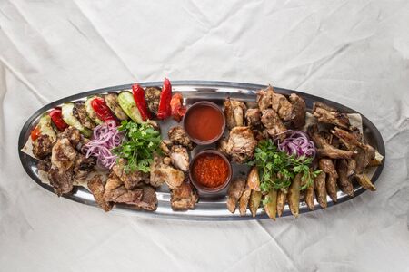 grilled meat assortment lamb, chicken and pork shish kebab and grilled vegetables on metal platter top viewの写真素材