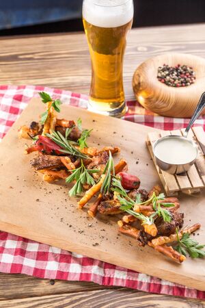 Beer snack bbq chicken wings and Smoked Cheese Suluguni and glass of lager beer On wooden table side viewの写真素材