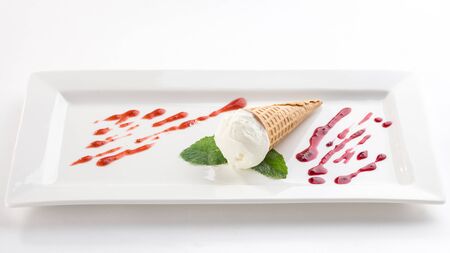Vanilla ice cream with mint leaf on white plate isolated on white background side viewの写真素材