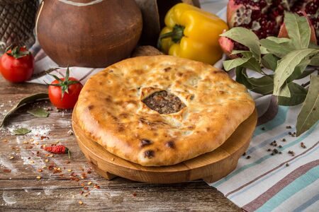 Traditional oriental cuisine Meat pie and fresh vegetables on wooden table side viewの写真素材