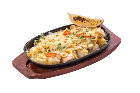 Casserole with salmon, potatoes and slice of lemon in metal pan isolated on white background side viewの写真素材