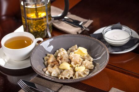 Dumplings, Varenyky, vareniki, pierogi, pyrohy filled with curd cheese on wooden table at restaurant side viewの写真素材