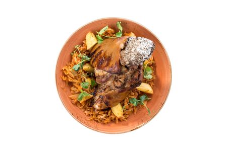 Pork knuckle roast served with cabbage and potato on orange plate isolated on white background top viewの写真素材