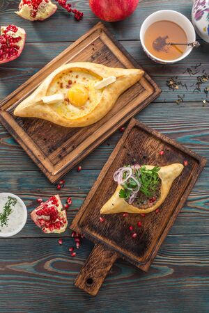 Traditional Georgian khachapuri bread with cheese and meat on wooden table top viewの写真素材