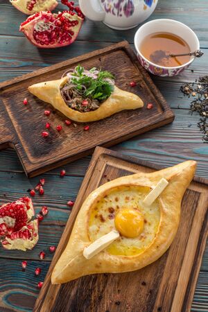 Traditional Georgian khachapuri bread with cheese and meat on wooden table top viewの写真素材