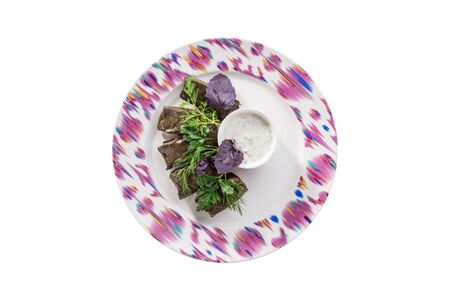 plate of delicious stuffed grape leaves with ground meat sour cream isolated on white background top viewの写真素材