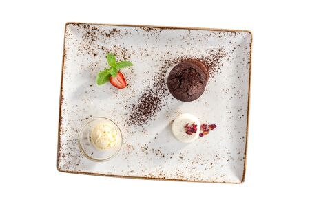 Warm chocolate fondant dessert with ice cream and strawberry on plate isolated on white background top viewの写真素材