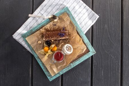 Piece of chocolate cake with strawberry jam on black wooden table top viewの写真素材