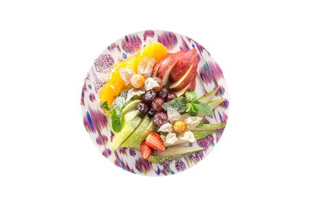 Raw fruits assortment with orange, pear, grape and apple on plate isolated on white background top viewの写真素材