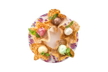 Colorful scoops of ice cream with different flavors in edible caramel bowl isolated on white background top viewの写真素材