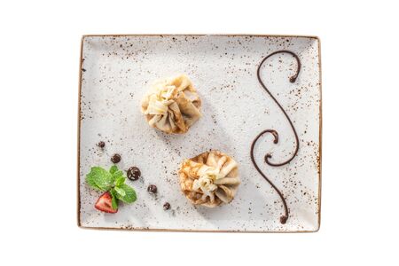 delicious dessert pancakes with filling on square plate isolated on white background top view