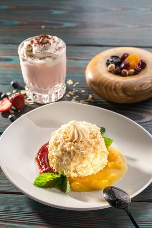 Cake Napoleon puff pastry dessert with strawberry and mango sauce and strawberry milkshake on wooden table side viewの写真素材
