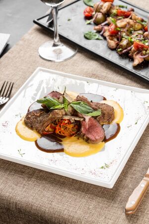 Grilled lamb ribs and chops with yellow and red sauce on the table at restaurant side viewの写真素材