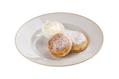 fried cottage cheese pancakes with sour cream isolated on white background side viewの写真素材