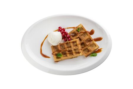 Belgian waffles with ice cream, caramel sauce and red currant isolated on white background top viewの写真素材