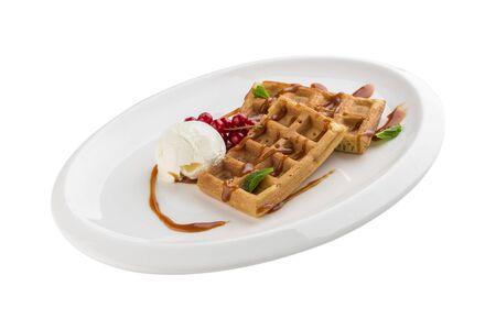 Belgian waffles with ice cream, caramel sauce and red currant isolated on white background side viewの写真素材