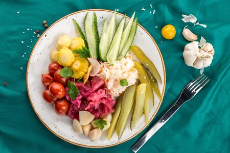 Pickled vegetables cucumber, tomato, garlic, cabbage Preserved food on turquoise background top viewの写真素材