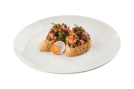 chopped roast beef with onion on bread toast bruschetta on white plate isolated on white background side viewの写真素材