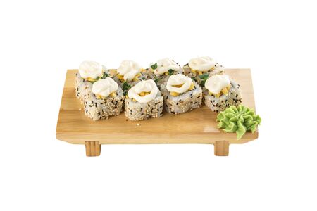 Sushi maki rolls with sesame seeds and mayonnaise on top on wooden board isolated on white background side viewの写真素材