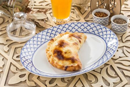 Fresh baked cheese patty bread on oriental wooden table side viewの写真素材