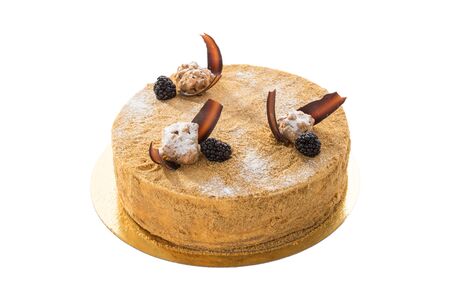 Sweet honey cake on golden platter isolated on white background side viewの写真素材