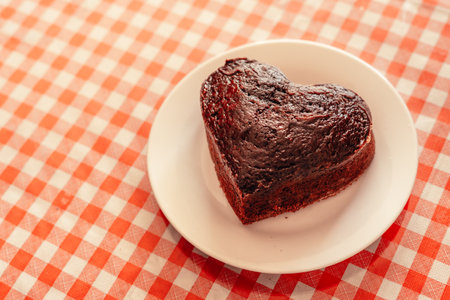 chocolate cake in the shape of a heart on a kitchen table