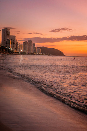 A captivating visual journey to Santa Marta, Colombia, blending breathtaking aerial perspectives with the serene beauty of its beaches. The collection features a stunning view from an airplane window, revealing the expansive white wing against a clear blue sky, with distant mountains and clouds hinting at the approach to a beautiful coastal destination. Complementing this is a serene sunset scene over the ocean near a beach, where a small boat gracefully traverses the calm waters under a vibrant orange sky, capturing the tranquil and picturesque essence of Santa Marta's Caribbean charm and inviting beach escapes. This set is ideal for showcasing travel, adventure, and the diverse beauty of Colombian landscapes and its coastal attractions.の写真素材