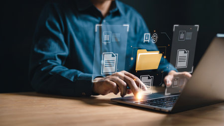 Businessman Managing Digital Files and Folders on Laptopの素材