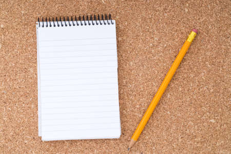 Spiral Notepad and Pencil over cork surfaceの写真素材