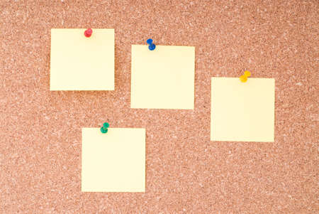 Yellow Note Papers With Tacks On Cork Surfaceの写真素材