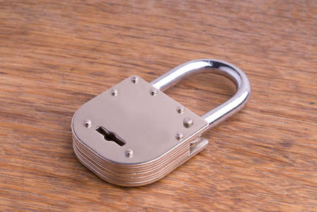 Closed Old Style Padlock on a Wooden Tableの写真素材