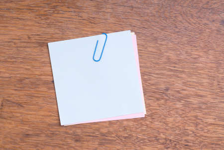 Note Paper With Paperclip On Wooden Table