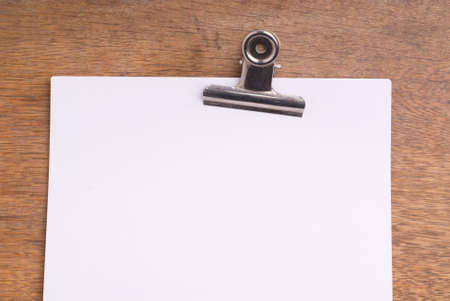 White Paper with Paperclip on a wooden tableの写真素材