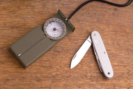 Military Style Compass and Pocket Kinefe on a Wooden Tableの写真素材