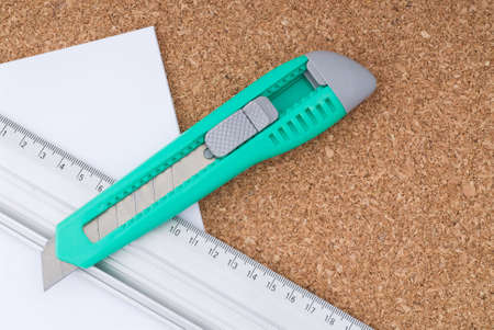 Box cutter, Ruler and Paper on a Cork Board の写真素材