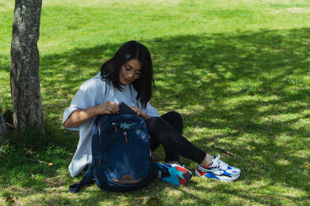 Beautiful college student in a time of rest and reading in the park.の写真素材
