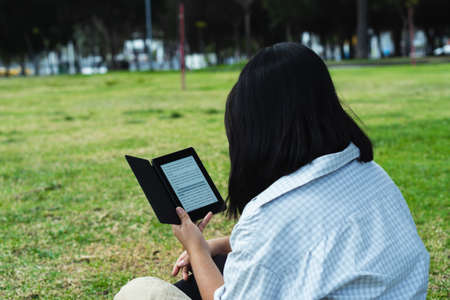 Beautiful college student in a time of rest and reading in the park.の写真素材
