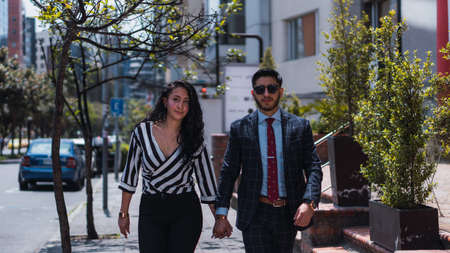 Couple of empresses walking in the city with elegant suits and happy