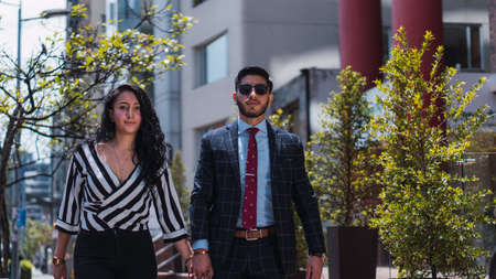 Couple of empresses walking in the city with elegant suits and happyの写真素材