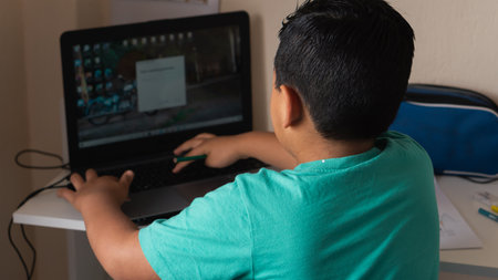Child receiving virtual classes with a teacher at home.の写真素材