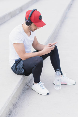 Young man listening to music to perform different exercises and get inspired.の写真素材