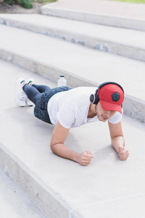Young man listening to music to perform different exercises and get inspired.