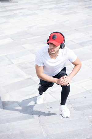 Young man listening to music to perform different exercises and get inspired.の写真素材