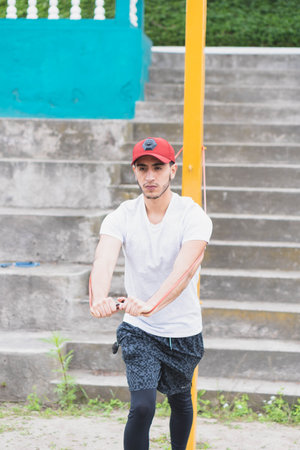 Young man listening to music to perform different exercises and get inspired.